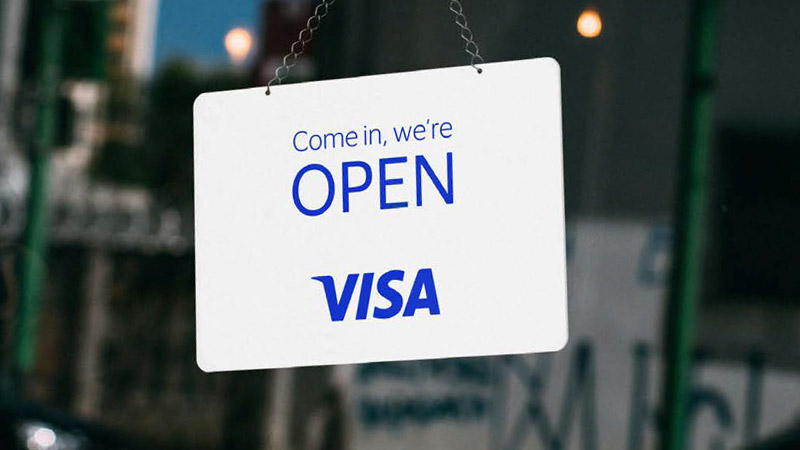 An "open" sign hanging on a store door, symbolising the widespread use of Visa small business tools
