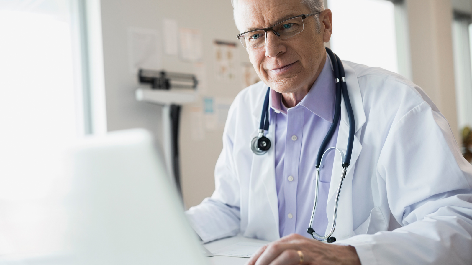 Doctor in office using laptop. Doctor in office using laptop.