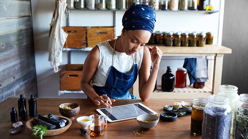 Woman in aromatherapy store working on her tablet.