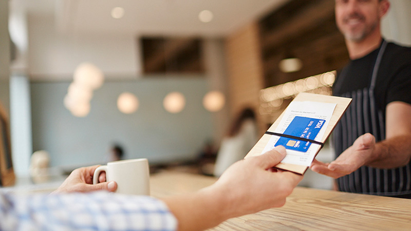 Shopkeeper accepting Visa card for payment