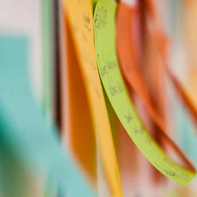 Close up of green and orange post-it notes.