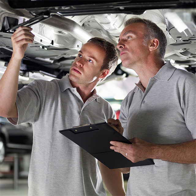 two men doing repair under the vehicle