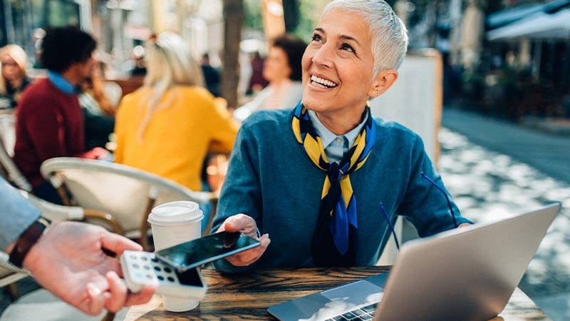 Woman paying for lunch with her Visa Card